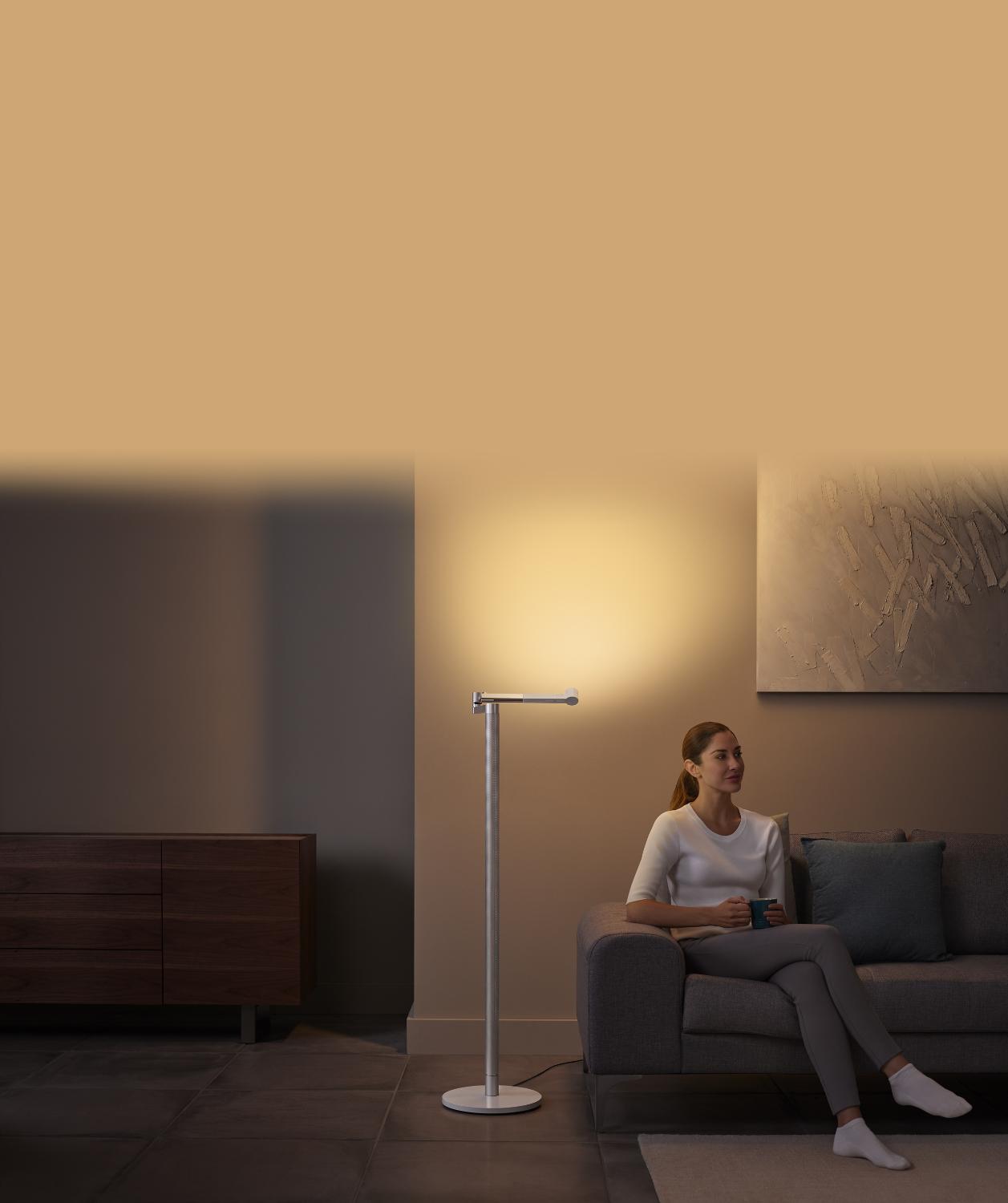 Vrouw die zich ontspant bij de stijlvolle indirecte verlichting van de Dyson Solarcycle Morph lamp
